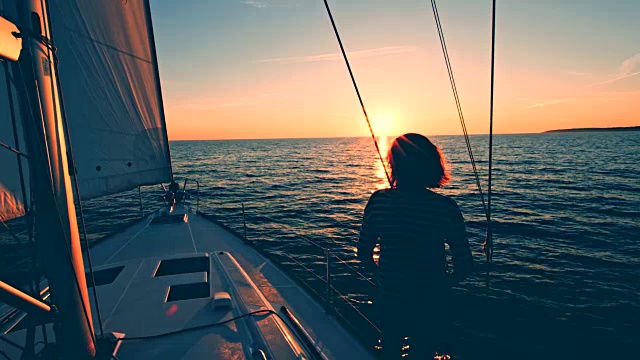 一个女人从一艘帆船的甲板上看日落视频素材