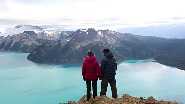 一对年轻夫妇站在山顶上欣赏风景视频素材