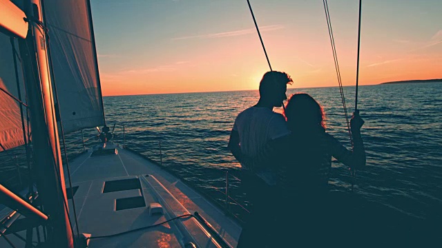 一对相爱的夫妇在一艘帆船上看日落视频素材