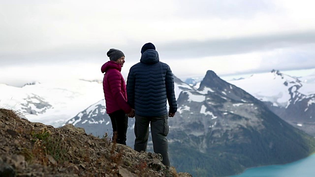 一对夫妻站在山顶上看风景视频素材