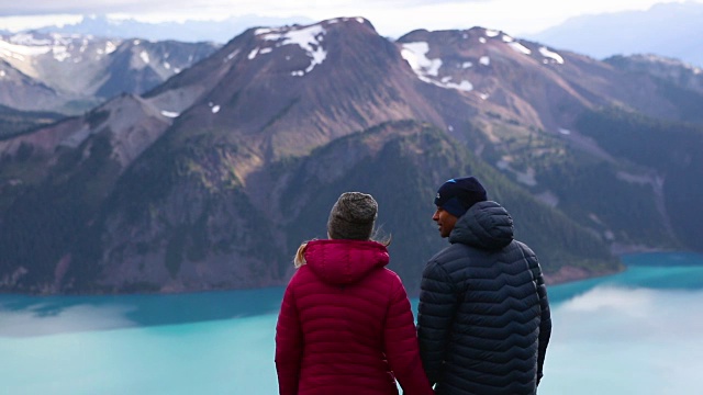 一对夫妇站在山顶上看美丽的景色视频素材