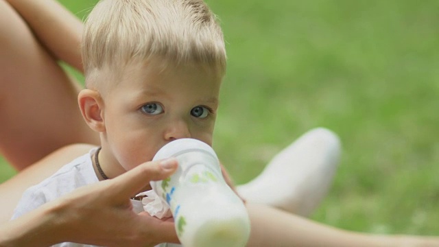 小男孩用婴儿奶瓶喝牛奶视频素材