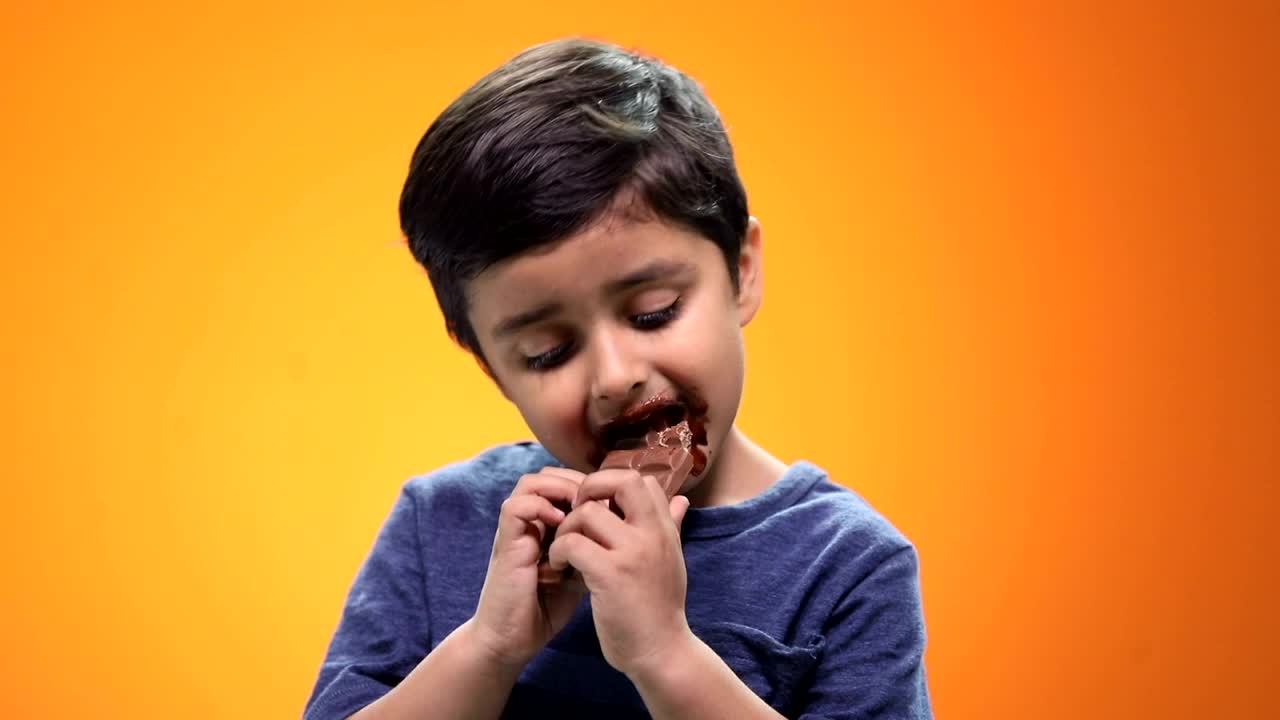 一个男孩吃巧克力的特写视频下载