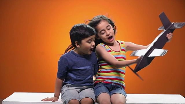 男孩和女孩在玩玩具飞机视频素材