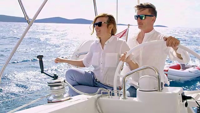 一对夫妇在海上驾驶一艘帆船视频素材