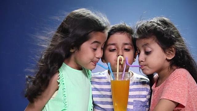 男孩和女孩喝着一杯果汁视频素材