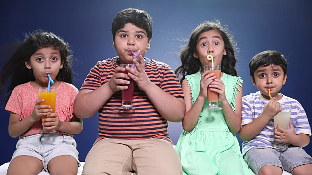 男孩和女孩喝果汁的肖像视频素材