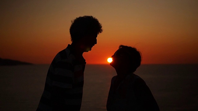 一对浪漫的老年情侣在夕阳下接吻视频素材