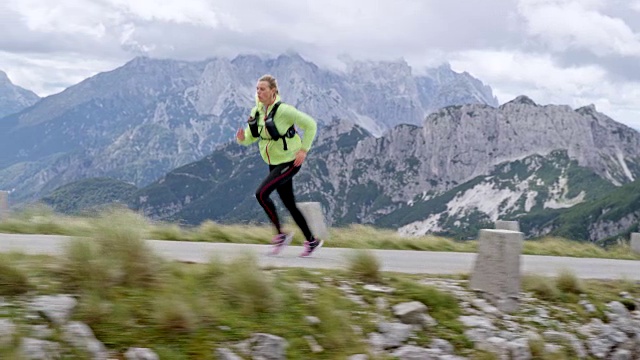 SLO MO TS女跑步者跑上一个高的山路视频素材