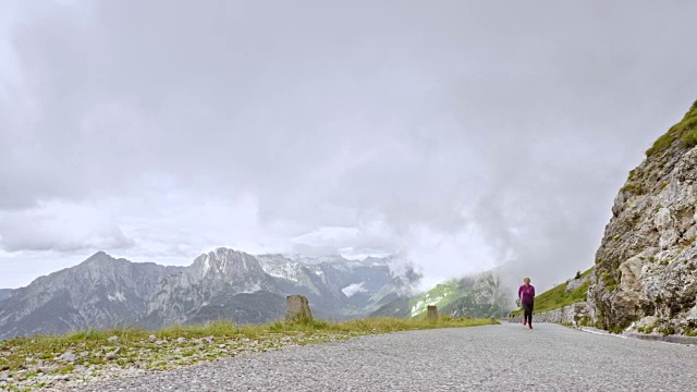 DS资深女跑步者在一条高山路上往山上跑视频素材