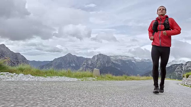 男子运动员在多云的天气跑上一条高山路视频素材