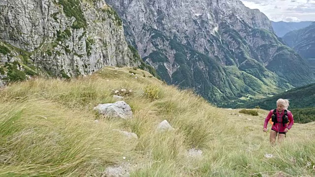 SLO MO DS一名男性和女性跑步者在陡峭的山坡上爬山视频素材