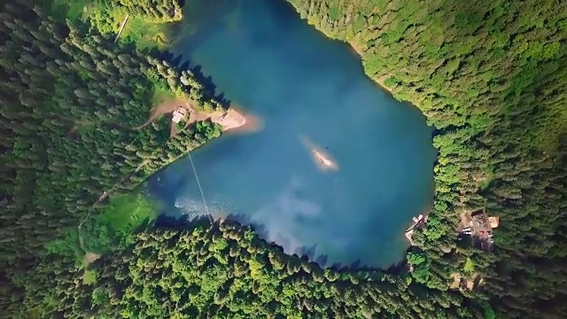 令人难以置信的美丽的蓝色湖泊被绿色的松树和冷杉包围在山上从上面看视频素材