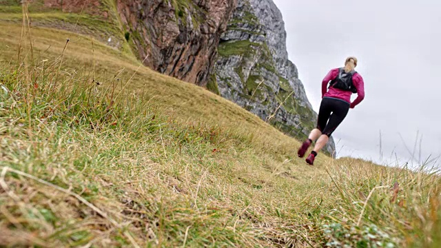一个女人在高山上的草地上奔跑视频素材