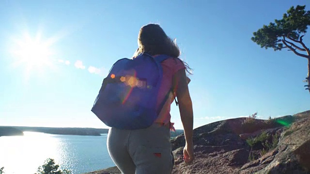 两个活跃的年轻女性互相帮助爬上一块高高的岩石视频下载