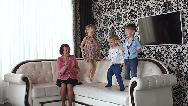 孩子们在沙发上蹦蹦跳跳。视频下载
