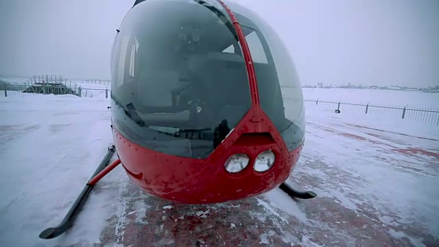 冬天，一架红色的直升机停在着陆点。视频下载