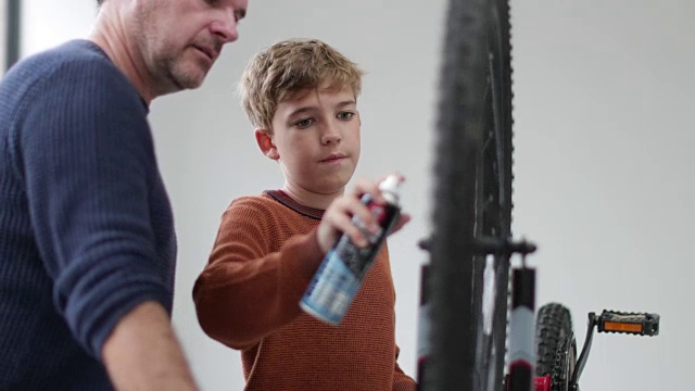 父亲教儿子如何安装自行车的新刹车视频素材