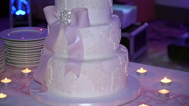 桌上放着漂亮的结婚蛋糕，上面插着蜡烛。视频下载