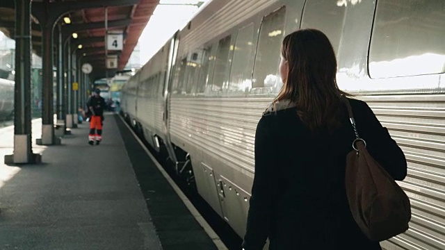 一个女人走在火车站的月台上视频下载