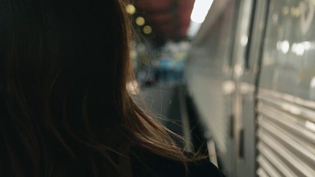 一个女人走在火车站的月台上视频素材