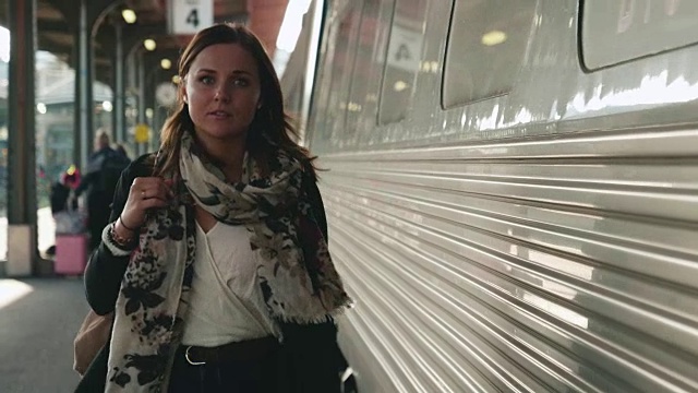 一个女人走在火车站的月台上视频素材