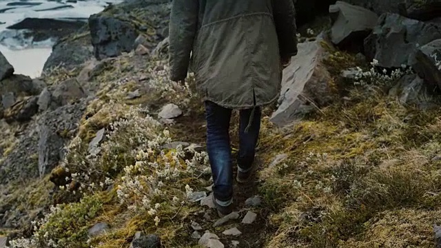 一名年轻的旅游男子徒步穿越冰岛Vatnajokull冰泻湖的山脉视频素材
