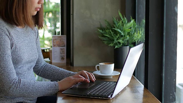 女人用她的笔记本电脑在咖啡馆放松时间，摄影视频下载