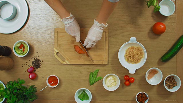 俯视图女性手切鱼，番茄，黄瓜，牛至，酱汁，奶酪视频下载