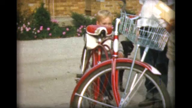 1957年，十几岁的男孩帮助小男孩骑上全尺寸自行车视频下载
