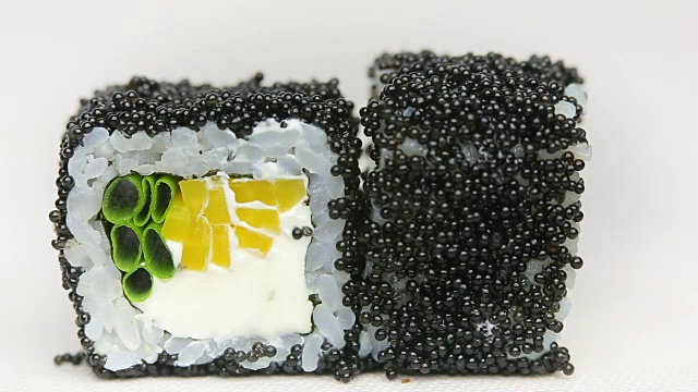 精致的黑鱼子酱卷在日本豪华餐厅主厨的寿司卷上旋转视频素材