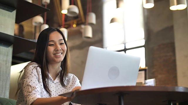 亚洲女人在咖啡馆用笔记本电脑，慢镜头视频下载