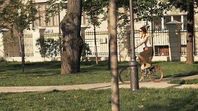 健身妇女在城市公园在夏天的一天骑自行车。女子自行车公园视频素材