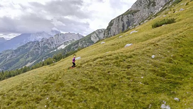 空中的女性跑步者跑上山上的草地视频素材