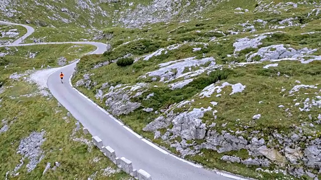 空中男子在高山上的公路上奔跑视频素材