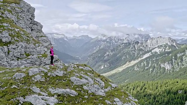 空中女跑步者站在山脊上，双手高高地举在空中视频素材