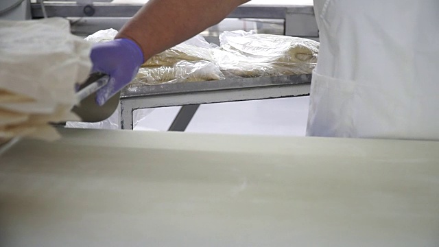 面包店里，一位妇女正在准备面团，准备制作面粉制品。特写镜头视频素材