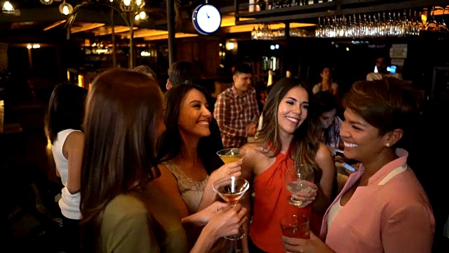 一群快乐的女性朋友在酒吧聊天和喝鸡尾酒视频素材