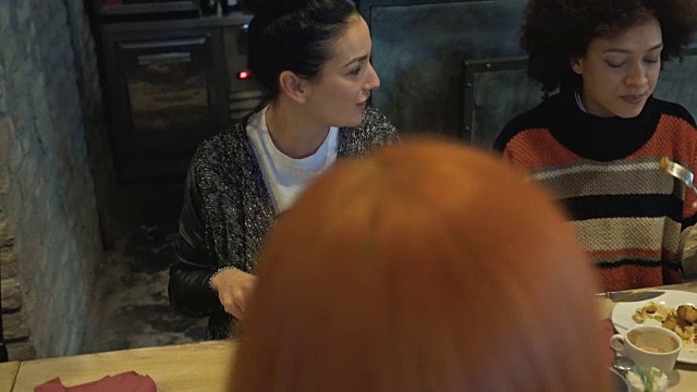 两个年轻的女人在一家餐馆吃午饭并交流。视频素材
