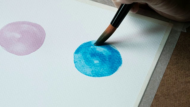 近距离拍摄的艺术家的画一个蓝色的cercal在水彩画使用画笔在水彩纸300 GSM。视频素材