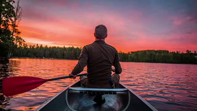 日落时分，一名男子划着独木舟视频素材