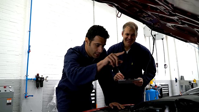 修理汽车引擎的机械师团队视频素材