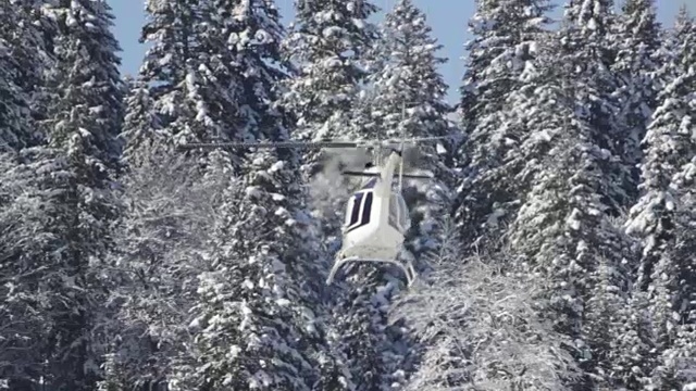 冬天的场景和一架直升机前往山区执行救援任务的镜头视频下载