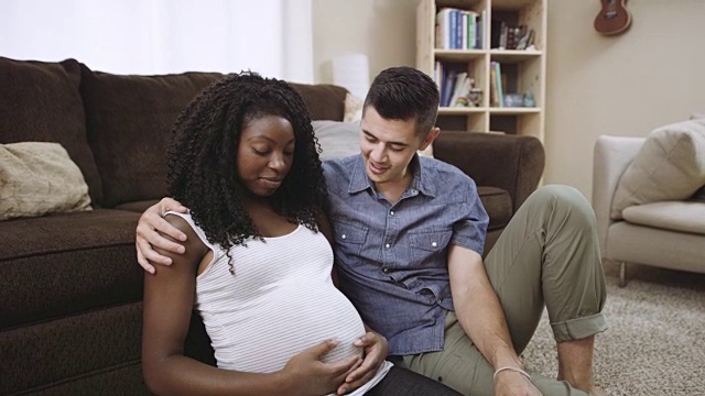 超高清4K SLO MO:迷人的混血怀孕夫妇微笑和触摸妈妈的肚子视频素材