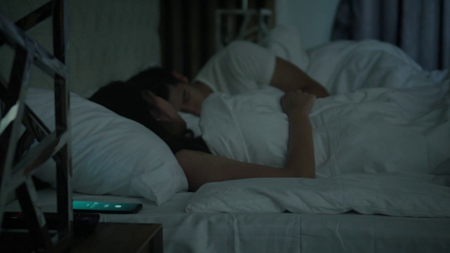 当智能手机响起警报时，一对情侣正在睡觉，多莉拍下了照片视频下载