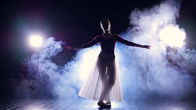 芭蕾舞演员在黑暗中做出完美的变形。视频素材
