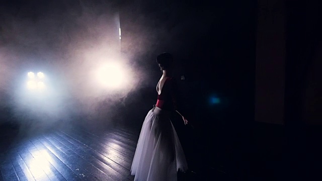 一位正在跳舞的芭蕾舞演员从黑暗中走出来。视频素材