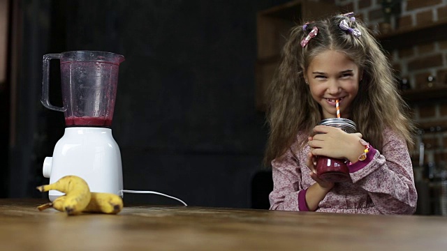 快乐的小女孩喝美味的浆果奶昔视频素材