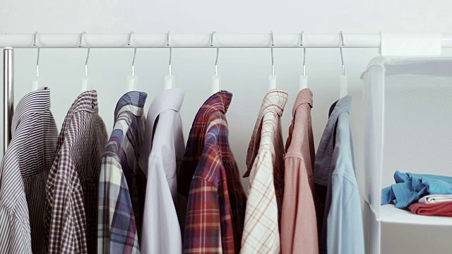 一个商人在他的衣柜里选择一件衬衫。视频素材