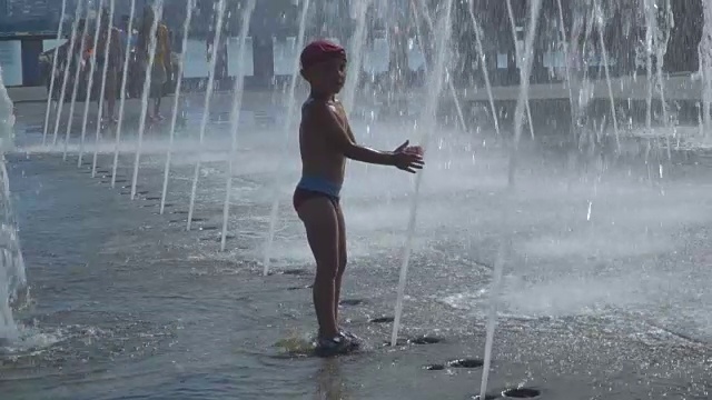 那个男孩正在喷泉里玩视频素材